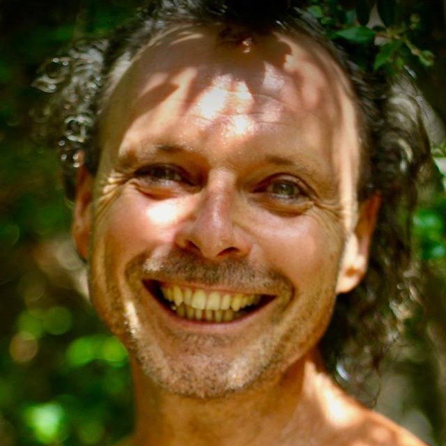 Ra, smiling, in the shade of the trees